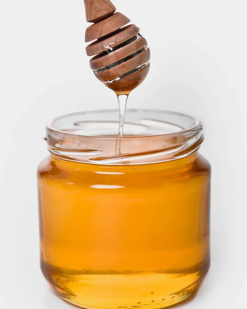 Worker hands holding a warm honey jar